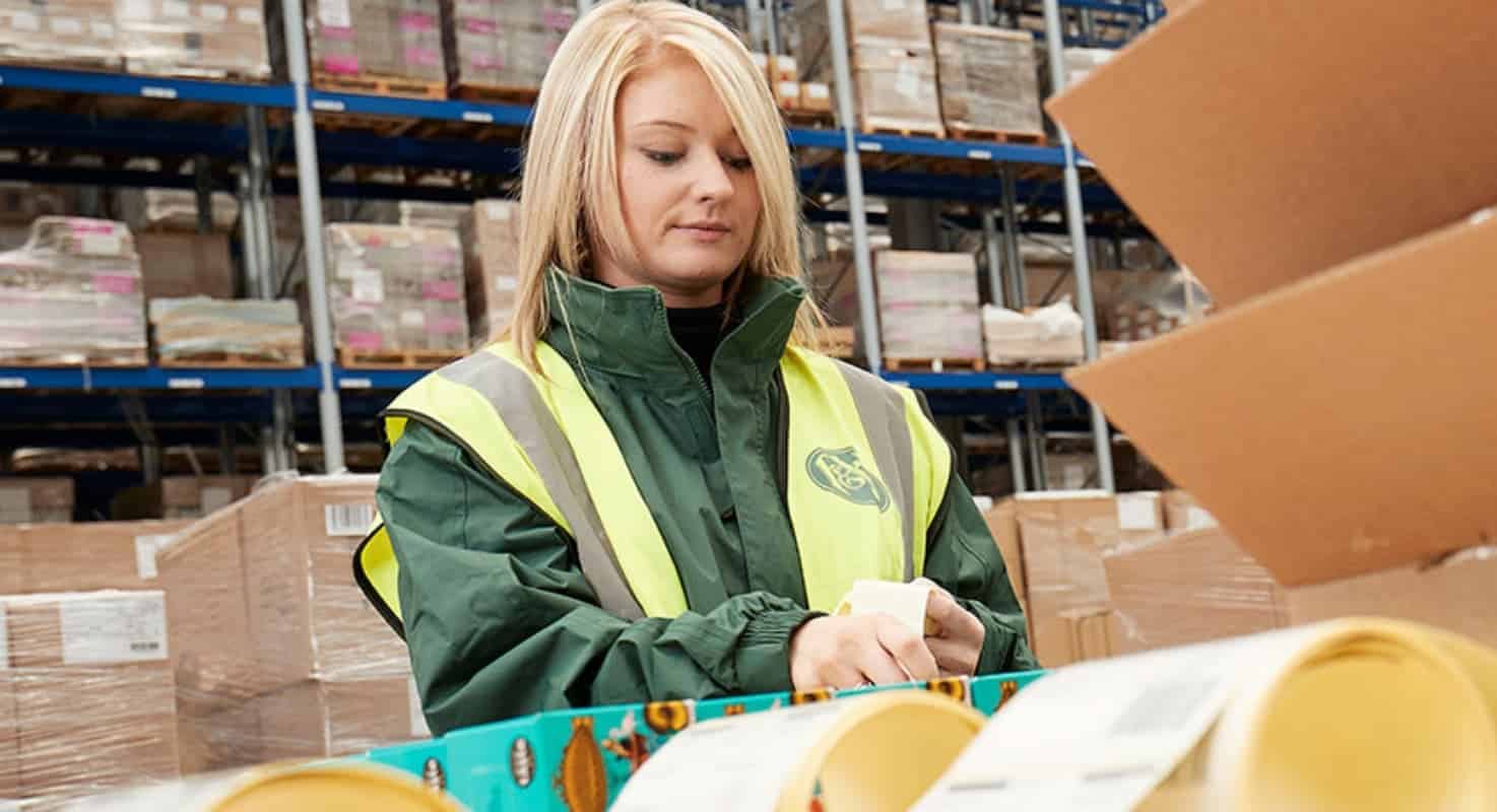 Employee labelling boxes in a warehouse